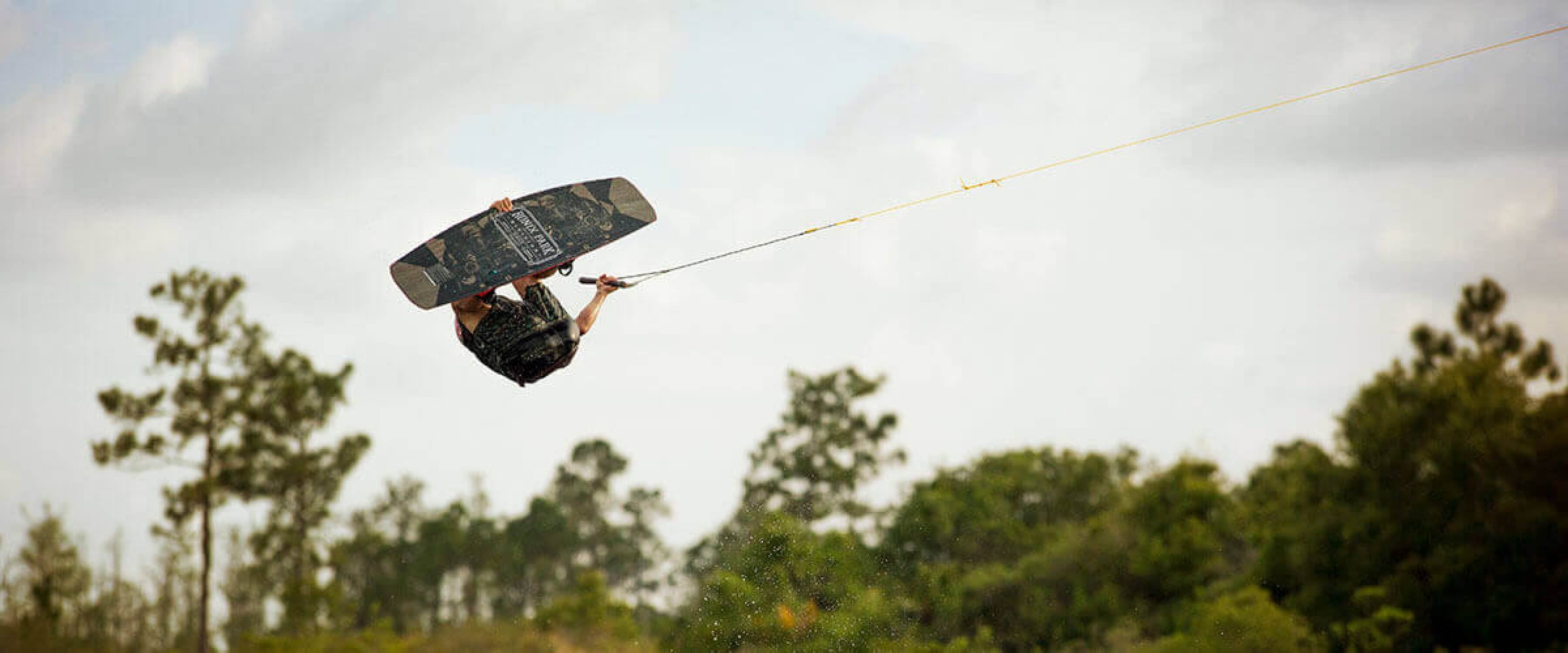 Wakeboarder flipping in the air.